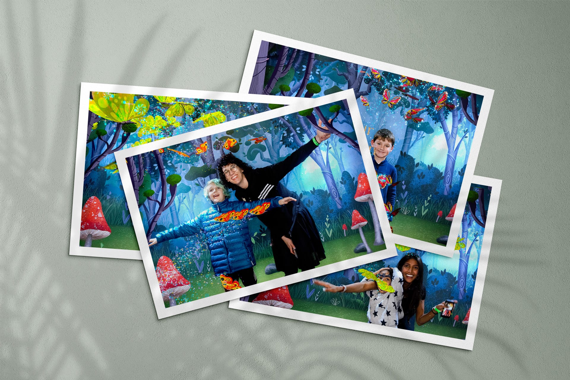 Four photo prints of families in the augmented reality butterfly photo booth