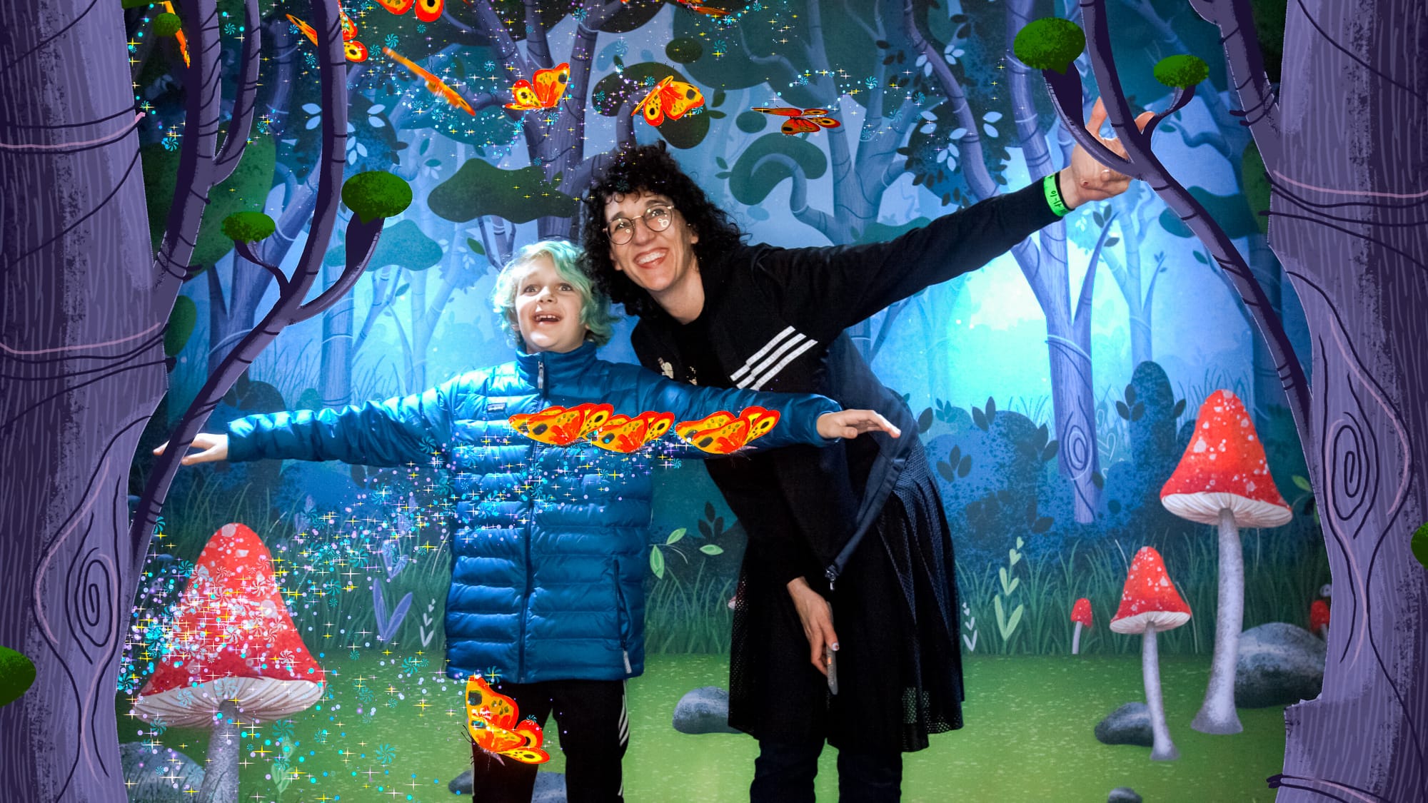 Mother and son pose with animated butterflies in the AR photo booth